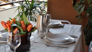 A table set for dining with a vase of orange tulips, wine glasses, and a bottle of wine. - Rome House Jambokella Apartment in the historic district of Monteverde  (Roma)