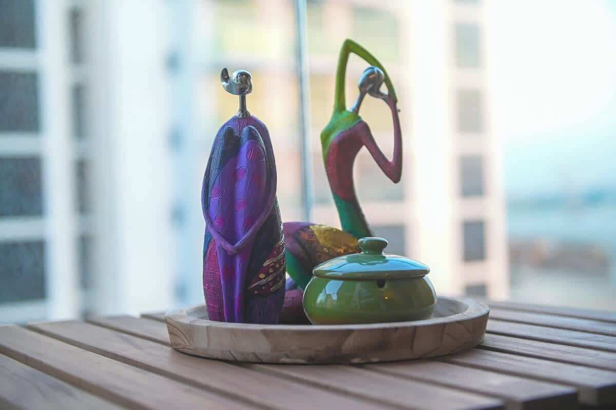 A table with a decorative ceramic piece and a green pot.