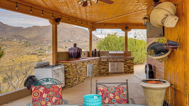 An outdoor patio with a barbecue grill, seating area, and a view of the desert landscape. - Views + Fire Pit: Hilltop Retreat in Rio Rico! (Rio Rico)