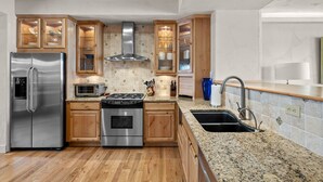 A modern kitchen with stainless steel appliances, wooden cabinets, and a granite countertop. - 3 Miles to Resort | Hot Tub | Fireplace | EV Charger | Great for Groups (Winter Park)