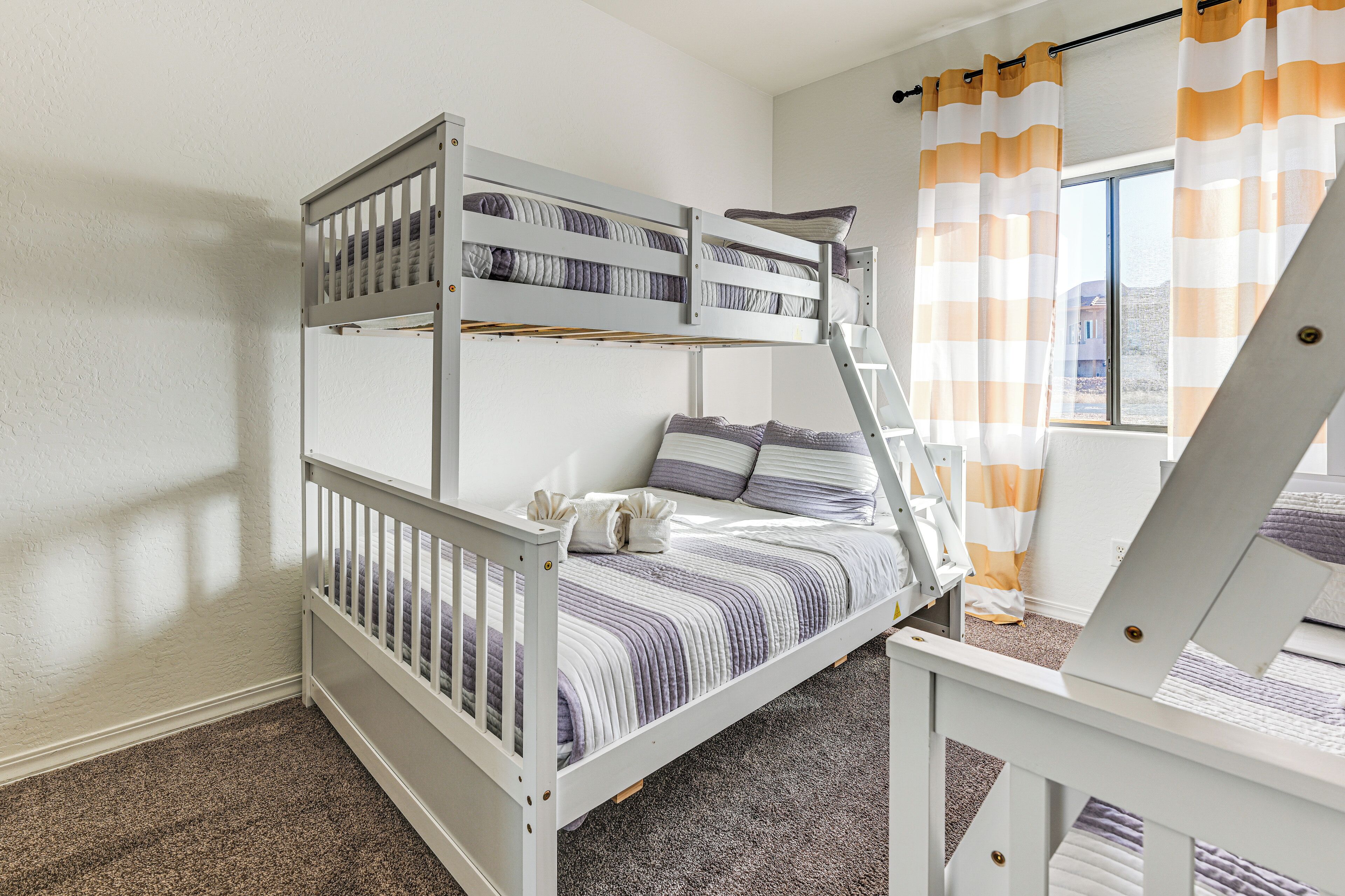 A bunk bed room with a window and curtains.