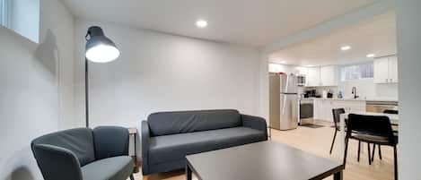 Una sala de estar moderna con un sofá, una mesa de centro y una lámpara de pie.