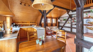 A rustic wooden interior with a dining area, kitchen, and living space. - Loft with sauna and fireplace (Schlitz)
