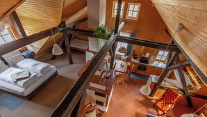 A loft-style room with a bed, a dining area, and a kitchen. - Loft with sauna and fireplace (Schlitz)