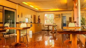 A restaurant with wooden tables and chairs, a tiled floor, and a ceiling with recessed lighting. - Northomes Pensione by HiveRooms (Bogo)