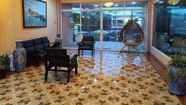 A lobby with a patterned floor, seating area, and large windows. - Northomes Pensione by HiveRooms (Bogo)