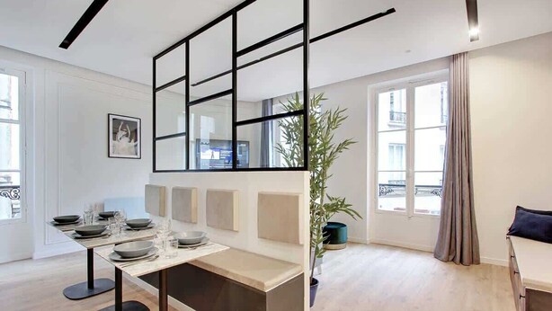 A modern living room with a dining area, a large window, a plant, and a sofa. - Superb apartment with AC - Center of Paris (Paris)