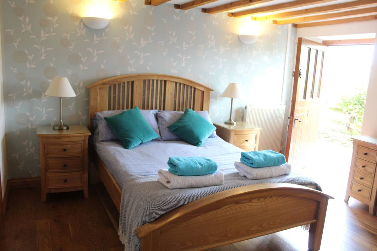 A bedroom with a wooden bed, two nightstands, and a wooden wardrobe.