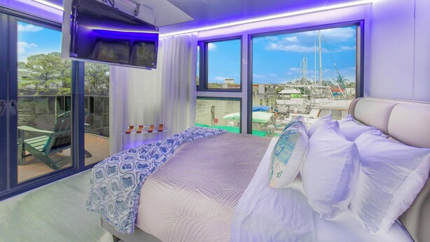 Een slaapkamer met een bed, een raam en uitzicht.