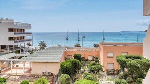 A coastal residential area with buildings overlooking the sea, featuring balconies and a clear view of sailboats. - Exceptional sea view in Lavandou (Le Lavandou)
