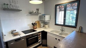 A compact kitchen with a microwave, toaster, and sink.