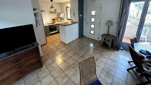 A compact living space with a kitchen, dining area, and a TV.