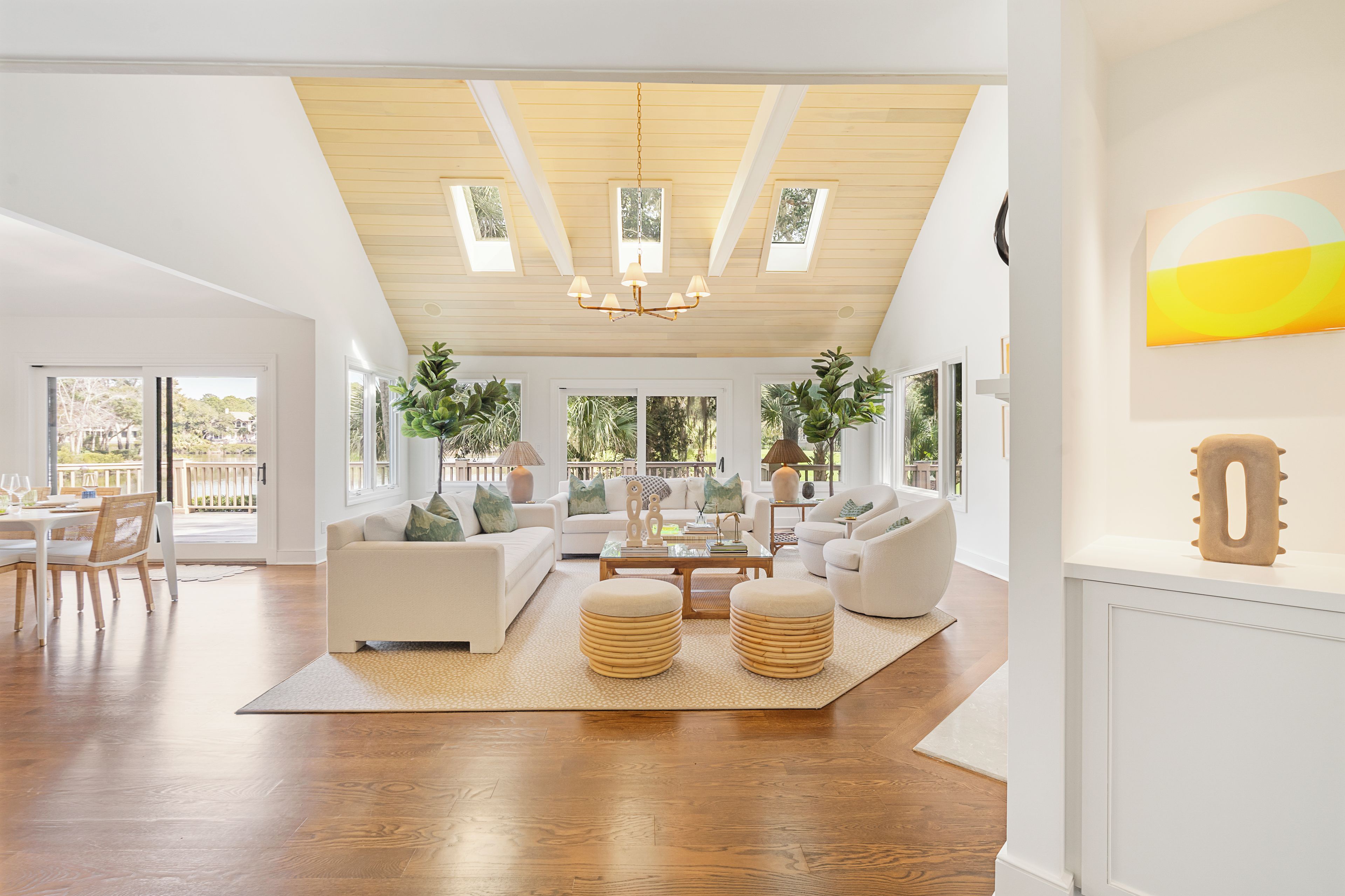 Un salon spacieux avec un haut plafond, de grandes fenêtres et un coin repas.