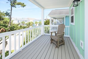 A wooden deck with a white railing, a single wooden chair, and a view of neighboring houses. - Walk to the Beach 7 BR Beach House with Private Pool! - Schedule Sea (Surfside Beach)