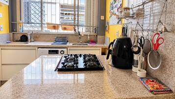 A kitchen with a gas stove, a coffee maker, and various kitchen utensils.