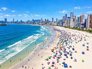 A beach with a city skyline in the background. - Ap Punta Cana em Balneário Camboriú - SC (Balneário Camboriú)