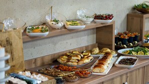 A buffet with various food items including bread, salads, and desserts. - Badyan Hotel (Bukhara)