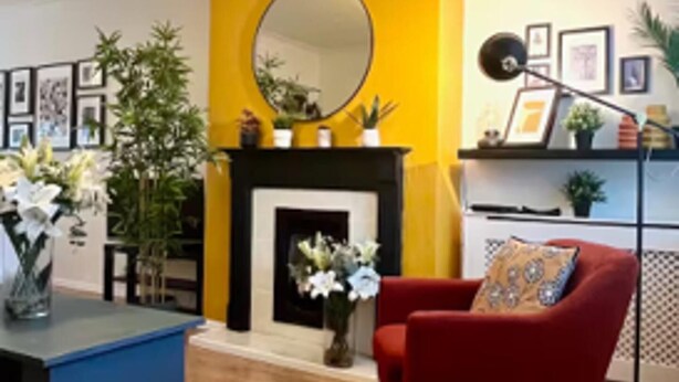 A living room with a fireplace, a red armchair, and a blue coffee table. - Woodcrest Retreat Sleeps 4 With Garden (Reigate)