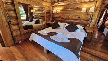 Ein schlicht eingerichtetes Schlafzimmer im Chalet-Stil mit einem großen Bett, einem Spiegel und zwei Wandleuchten.
