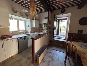 A kitchen with a central island, a dishwasher, and a window. - Charming 3-bedroom house with Swiming-pool and WiFi in Montbrison-sur-Lez (Montbrison-sur-Lez)