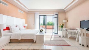 Une chambre d’hôtel avec un lit, une télévision, un bureau et un balcon offrant une vue.