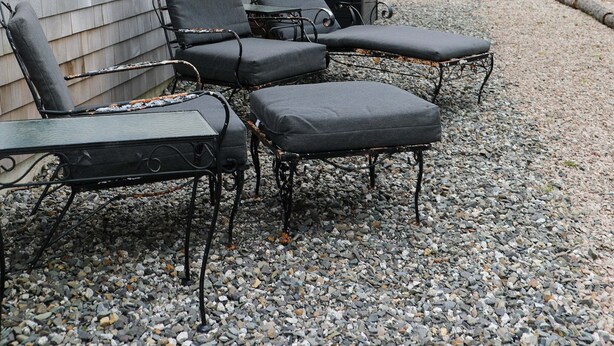 A house with a gravel patio, outdoor seating, and a forested backdrop. - This Maine House-Near Ocean! (Tremont)