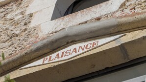A building facade with the word "PLAISANCE" on a stone ledge, a window with a metal railing, and greenery in front. - Large estate renovated with taste and comfort in the heart of nature (Cachen)