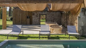 An outdoor pool area with lounge chairs and a pergola. - Large estate renovated with taste and comfort in the heart of nature (Cachen)