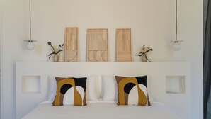 A modern bedroom with a large bed, two wall-mounted light fixtures, and three wooden panels above the bed. - Large estate renovated with taste and comfort in the heart of nature (Cachen)