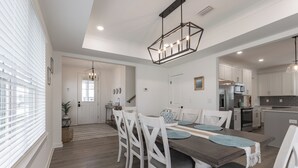 A modern kitchen with white cabinets, a built-in oven, and a stainless steel refrigerator. - Bay Breeze Retreat- So Close To All The Fun! Game Room! XL Home! (Orange Beach)