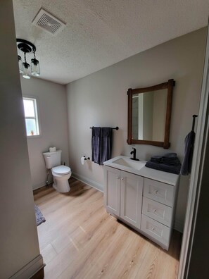 Bathroom features a toilet, sink, and towel rack.