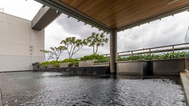 Un élément décoratif aquatique installé à l’intérieur, avec un plafond en bois et un mur en béton.