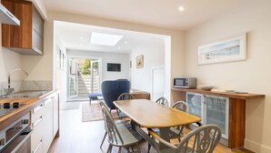 A modern kitchen with a dining area, built-in appliances, and a view to the outside. - Host & Stay | Prince Albert (Margate)