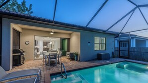 Un jardin avec une piscine, des meubles de jardin et un espace patio couvert.