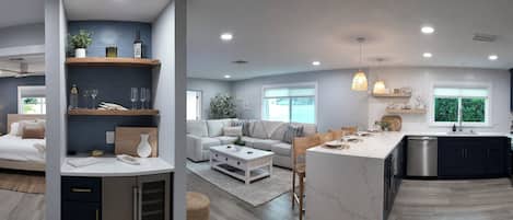 A modern kitchen with a central island, built-in appliances, and a dining area with a sofa and coffee table.