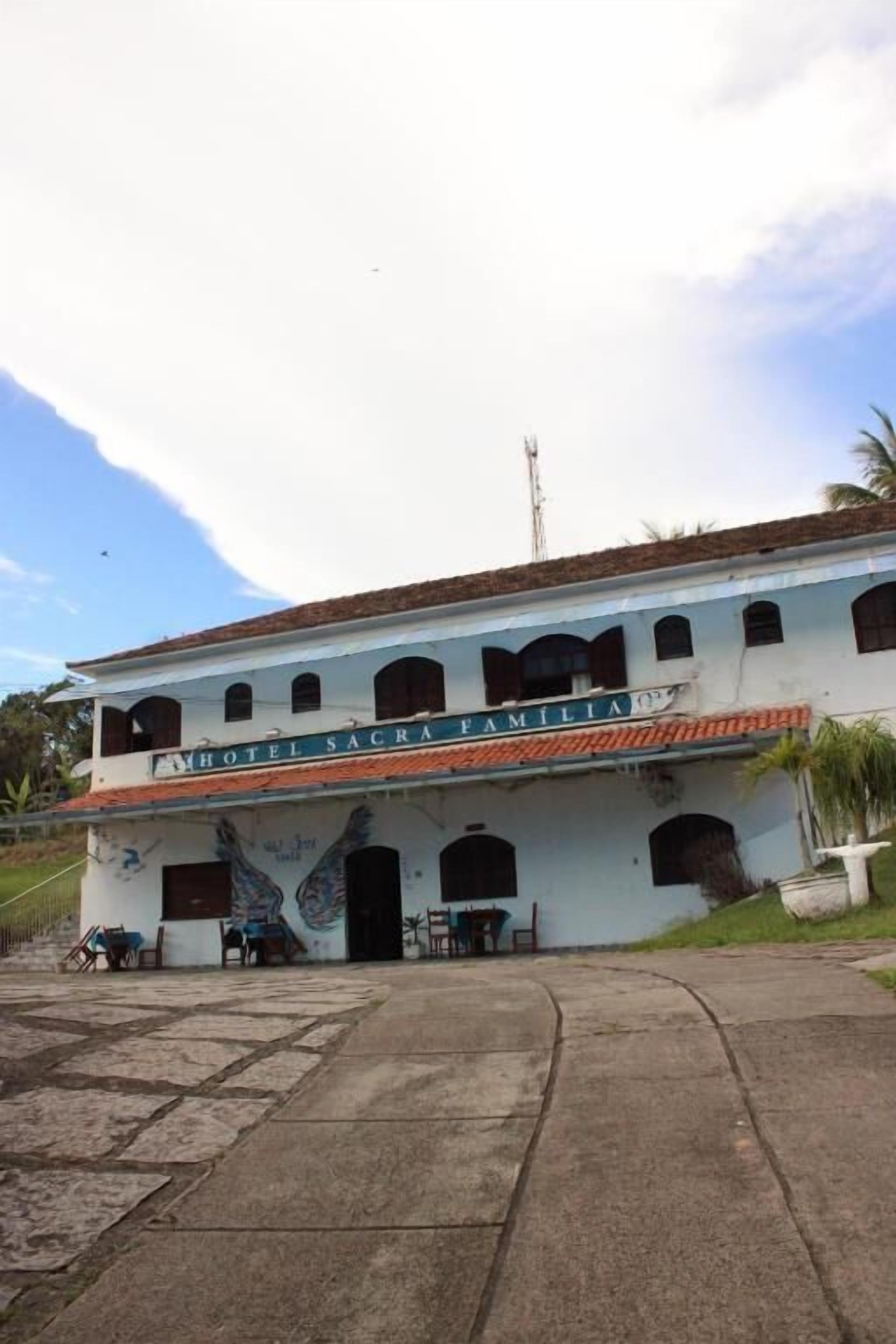 A two-story building with a sign reading "Hotel Sacra Familia."