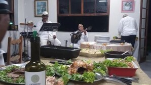 Un comedor con una mesa dispuesta para una comida, una botella de vino y una ventana decorada con globos.