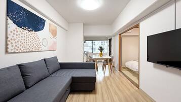 Family Apartment, Non Smoking | Living area | 50-inch Smart TV with cable channels