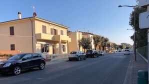 A street with parked cars and buildings. - 5 BEDS, in front of Bagno Paradisino (San Vincenzo)