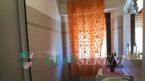 A bathroom with a toilet, bidet, sink, and a shower curtain. - 5 BEDS, in front of Bagno Paradisino (San Vincenzo)