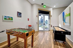 A room with a foosball table, a pool table, and artwork on the walls. - Escape to a 4BR Villa w/ Arcade, Pool & Mini Golf (Davenport)