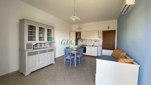 A compact living space with a dining area, kitchenette, and a small seating area. - TWO-ROOM APARTMENT SLEEPS 4 IN THE LA PIANA AREA (San Vincenzo)