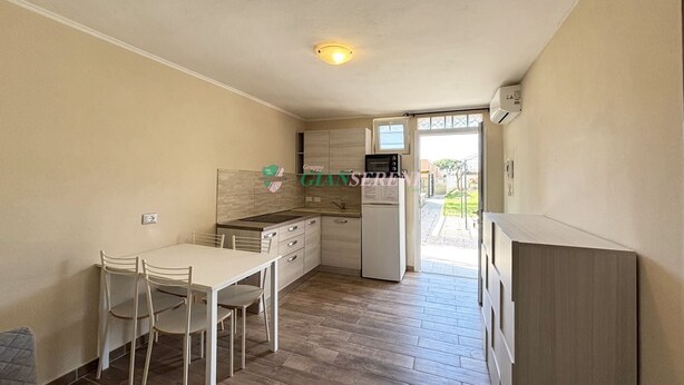 A compact kitchen with a dining area, a built-in oven, and a refrigerator. - 5 beds with garden and air conditioning (San Vincenzo)