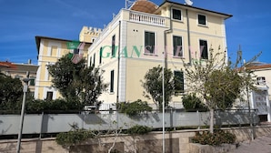 A two-story building with a balcony and a sign that reads "GIANNI SERENI".
