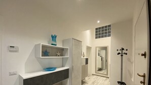 A modern bathroom with a vanity, shelves, and a mirror. - 5 bed places with parking space - ROSS2S (San Vincenzo)