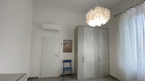 A bedroom with a wardrobe, a chair, and a bed. - 5 bed places with parking space - ROSS2S (San Vincenzo)