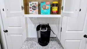 Eine Küche mit integrierter Kaffeemaschine, einer Gewürzleiste und einem Schrank voller Kaffee.