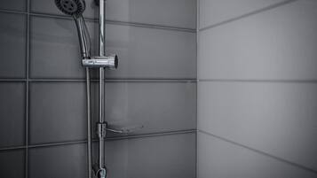 Ducha con cabezal de ducha manual y otro fijo en la pared.