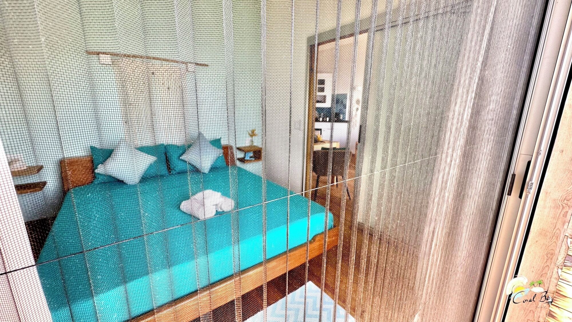 A room with a bed, a nightstand, and a window with curtains.