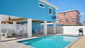 A backyard with a swimming pool, covered patio, and outdoor seating area. - ☀️ Private Pool - Short Walk to Beach - Betty's Beach House ☀️ (Fort Myers Beach)